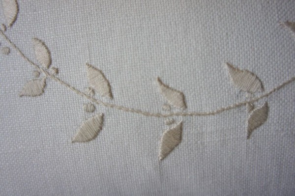 Sprig of leaves: hand embroidered detail of linen union cushion with initial 'J' 