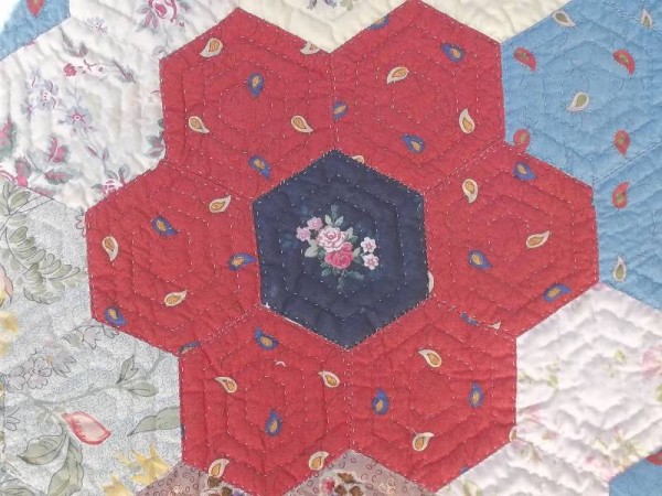 Grandmother's garden quilt showing detail of hexagons and hand quilting