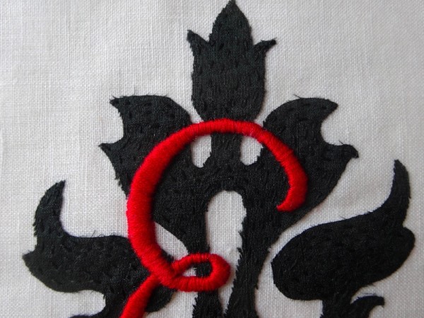 Scarlet and black monogrammed E: close up of detail