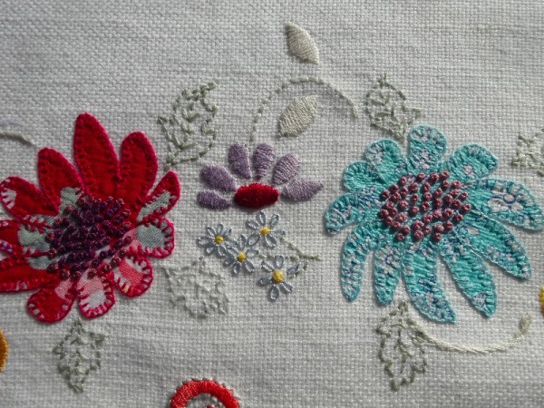 M monogram: detail of hand embroidered & appliquéd flowers 