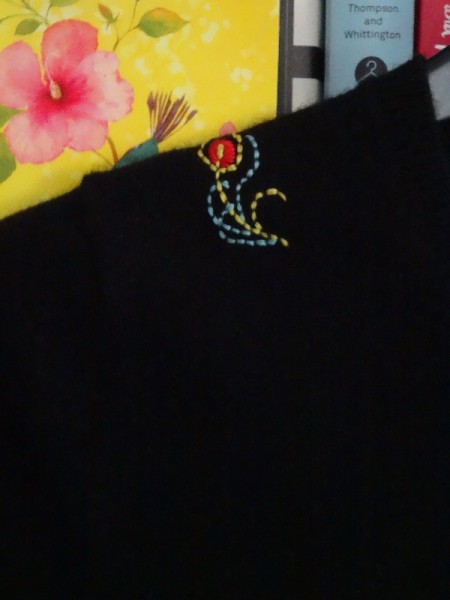 Brightly embroidered feather on black cashmere (hand embroidered by Mary Addison)