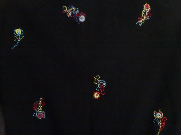 Brightly embroidered feathers on black cashmere (hand embroidered by Mary Addison)