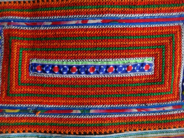 Red Mong skirt : detail of cross stitch and appliquéd ribbon border 